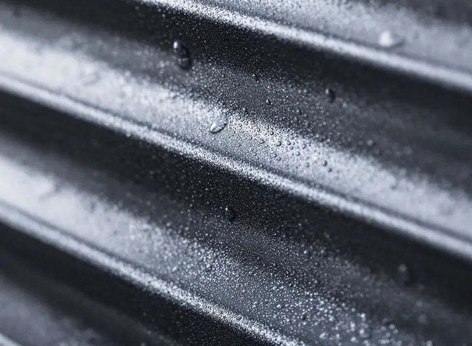 Close-up van gesloten antraciet aluminium lamellen met regendruppels